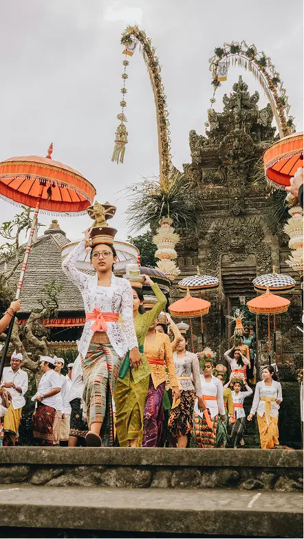 Happy tourists posing near Balinese temple gateways, experiencing cultural excursions in Bali
